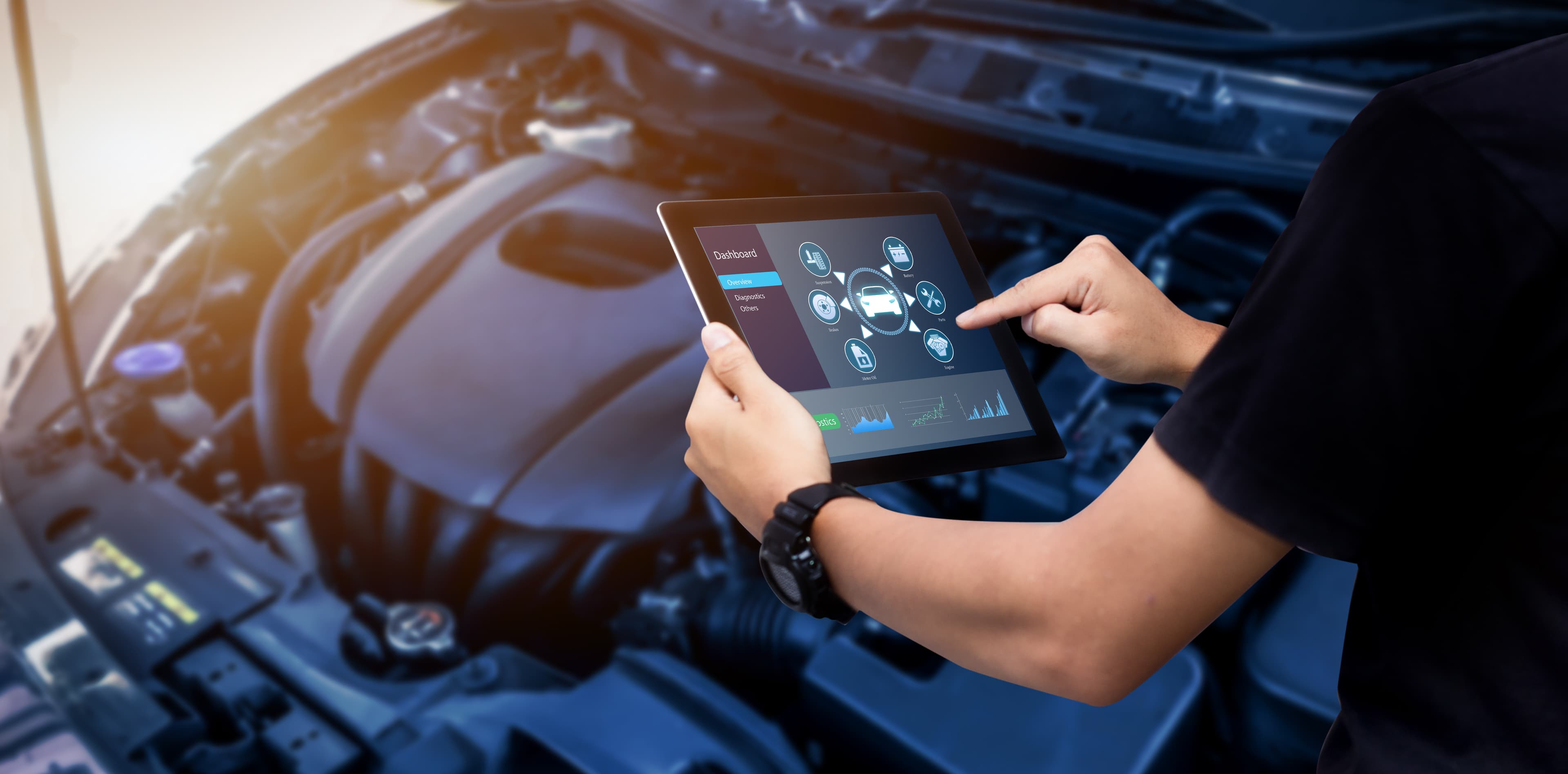 Technik diagnozujący problemy z silnikiem samochodu za pomocą cyfrowego tabletu z nowoczesnym oprogramowaniem motoryzacyjnym