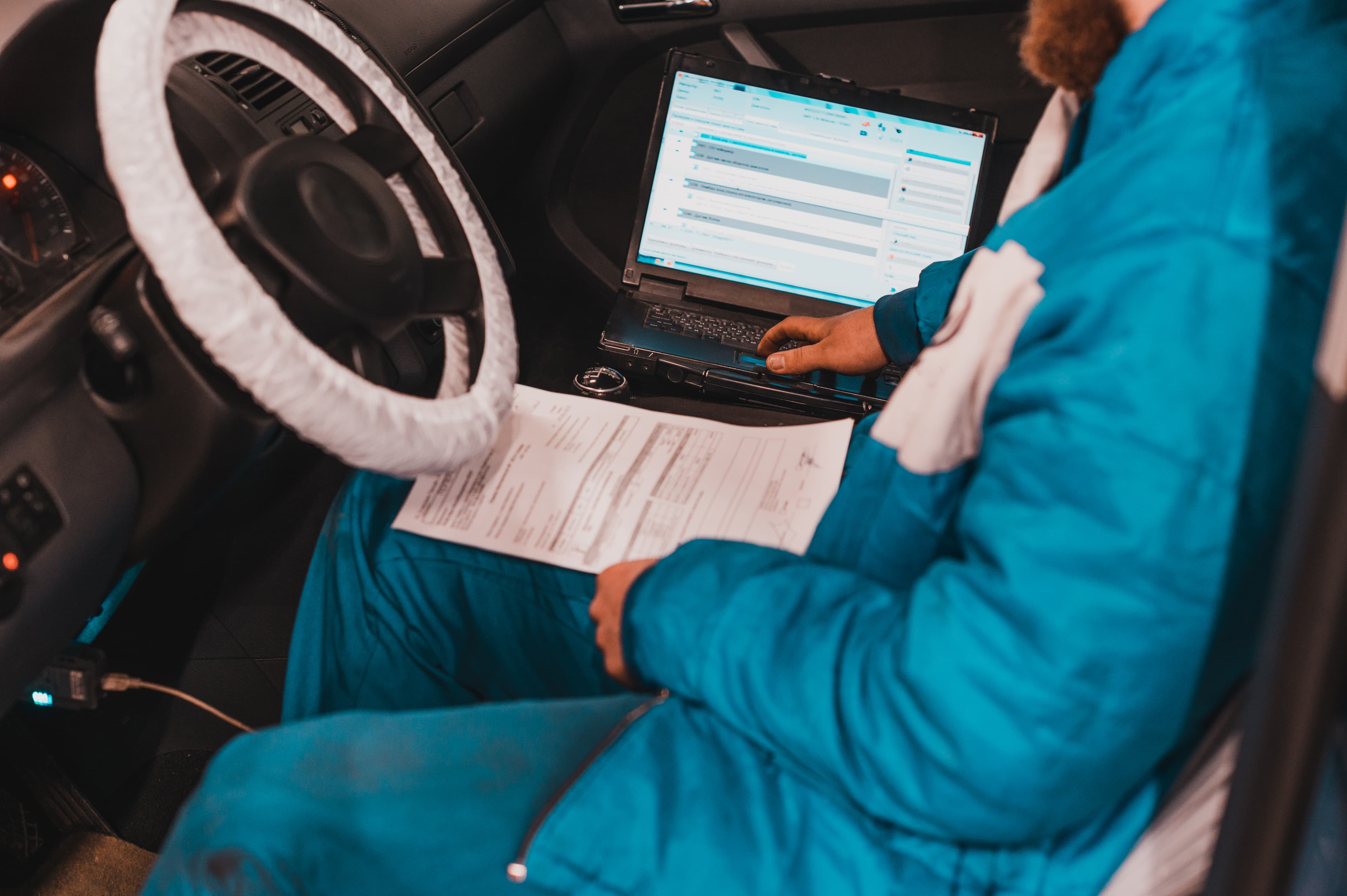 Mechanik naprawiający przekładnię kierowniczą pojazdu na podnośniku