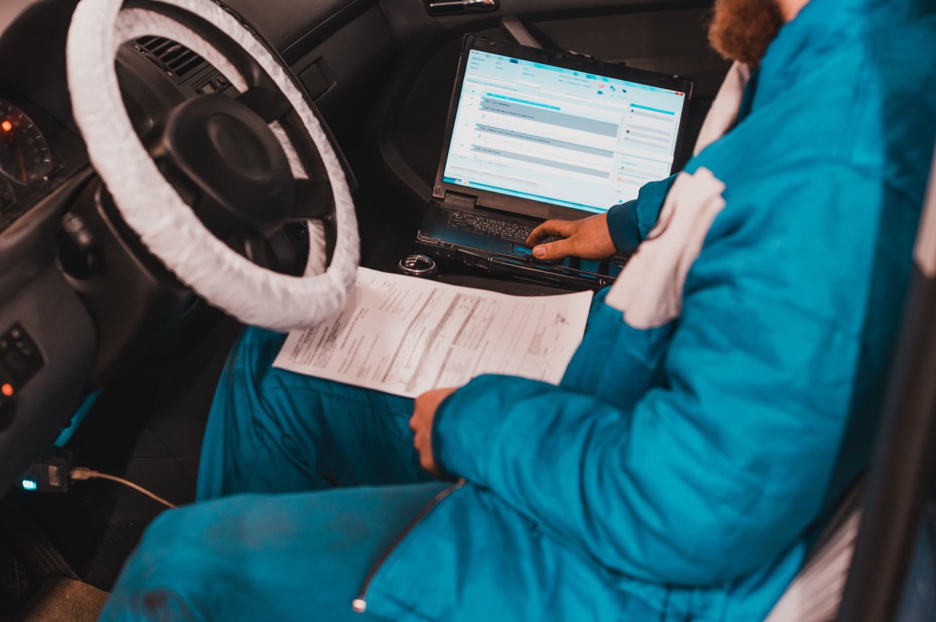 Mechanik naprawiający przekładnię kierowniczą pojazdu na podnośniku