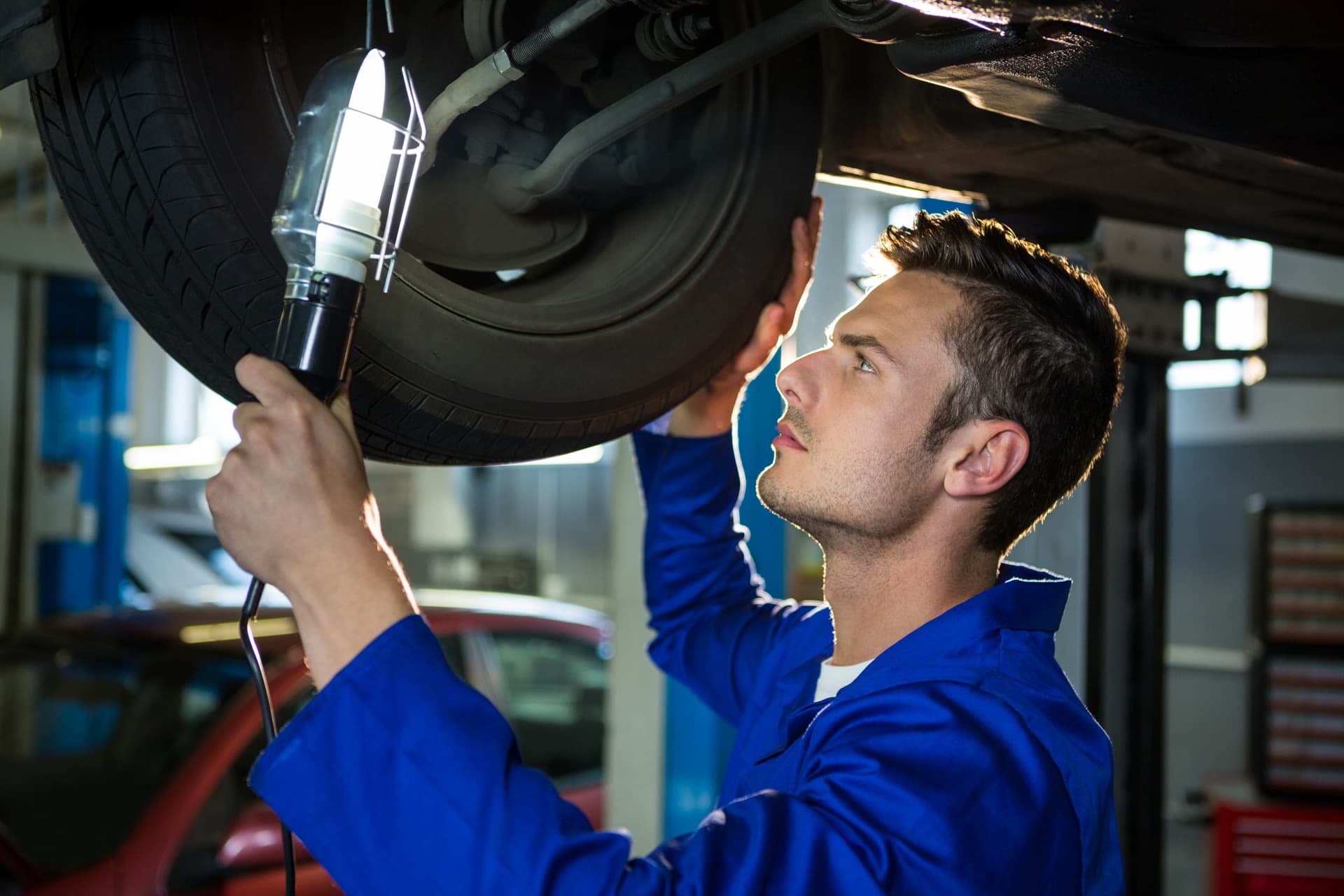 Technik wymieniający zużyte końcówki drążków kierowniczych