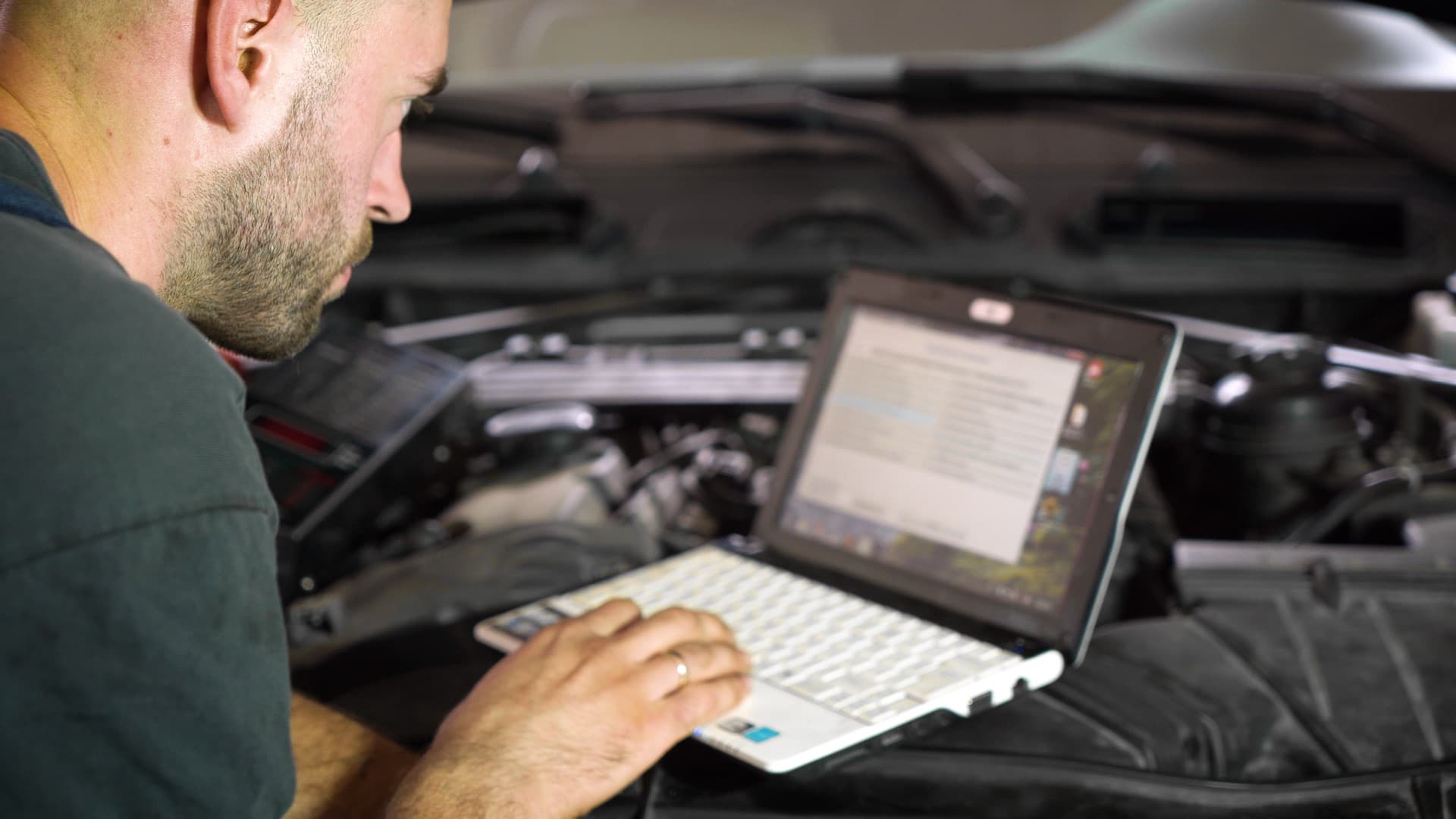 Mechanik sprawdzający system oświetlenia pojazdu podczas przygotowania do przeglądu technicznego